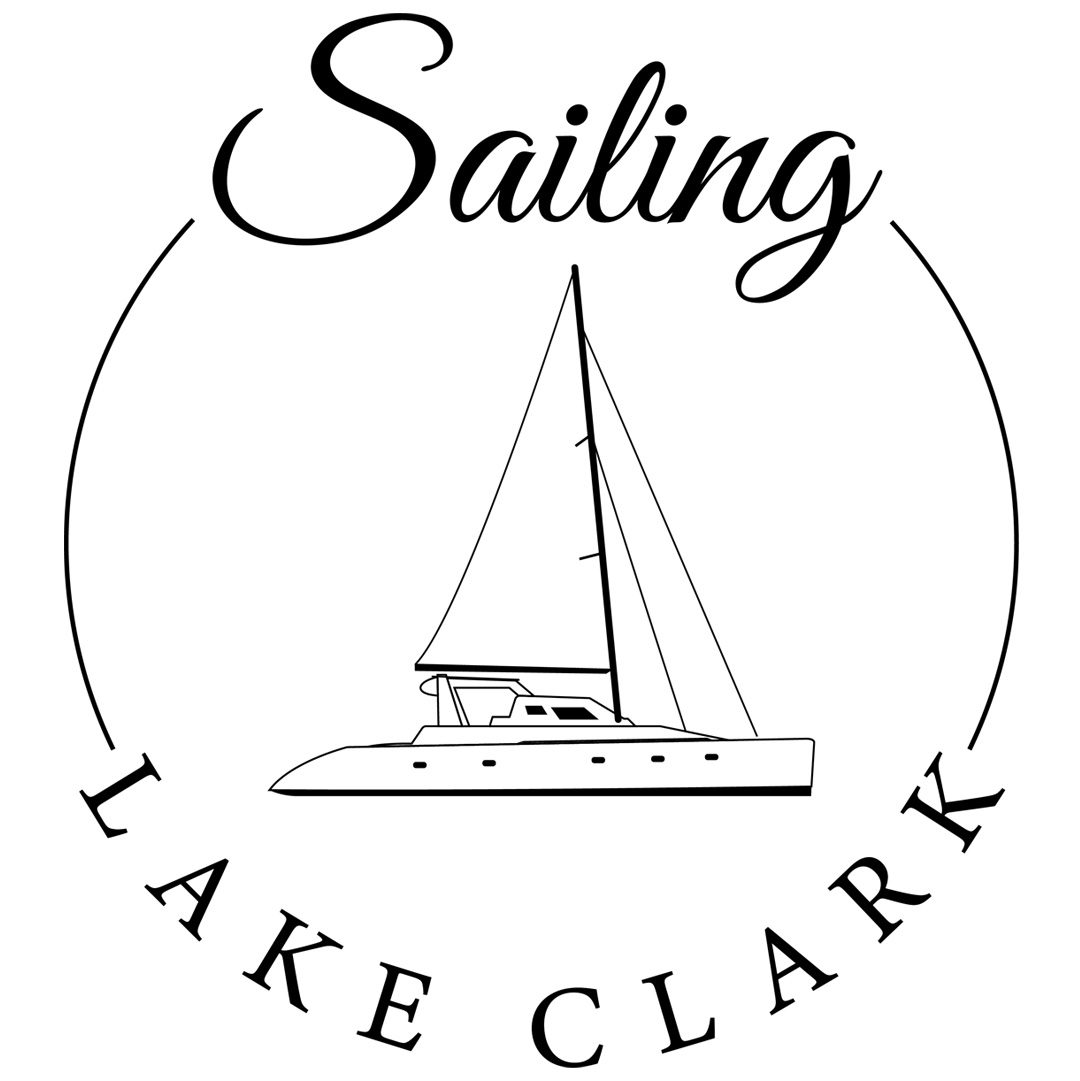 Logo featuring the word "sailing" at the top and "lake clark" at the bottom, encircling a stylized image of a sailboat on water.