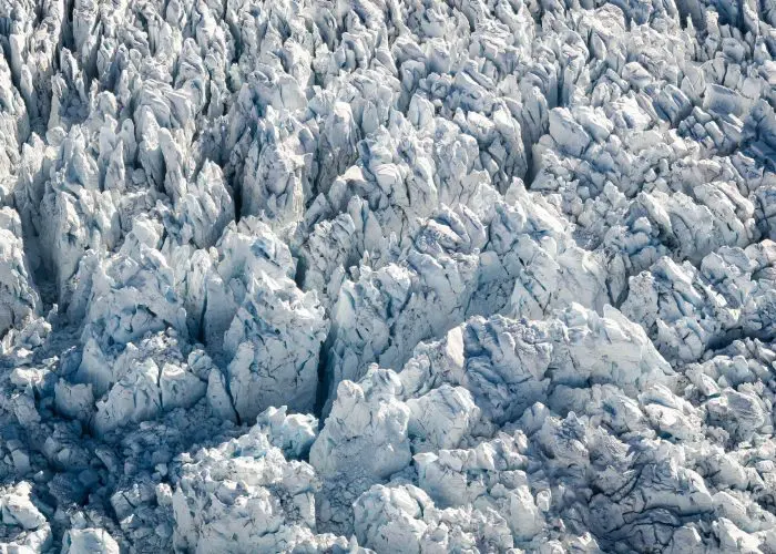 Aerial view of a glacier's jagged ice formations and crevices.